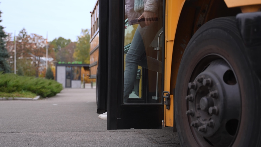 Close-up of cheerful multiracial high school students getting off yellow school bus hurrying to studies. Positive secondary school pupils jumping off steps of school bus rushing to their lessons Royalty-Free Stock Footage #1086417314