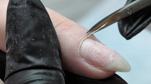 Pruning at the nail cuticle with manicure scissors. Hardware combined manicure.