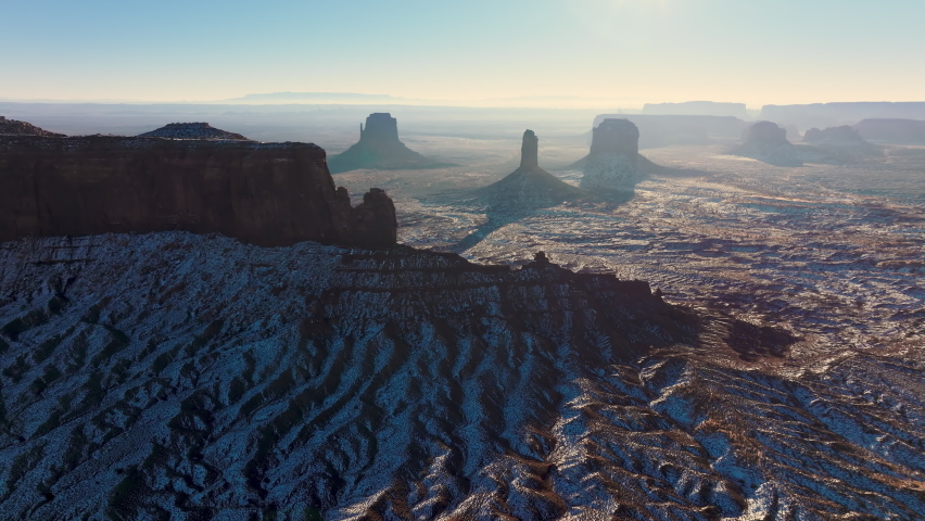 Scenic nature landscape, perfect for travel background and copy space Arizona USA 4K. Cinematic Monument Valley park on sunny winter day with fresh white snow covering the red sandstone desert surface