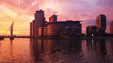 Manchester,01 07 2019: england:establishing shot wide angle view of salford quays waterside mediacityuk district at sunset