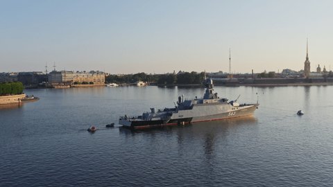 Russia, St. Petersburg, 27 July 2019: Aerial morning urban landscape with warship Serpuchov in the Neva River before the holiday of the Russian Navy, sea power, Rostral columns on a background
