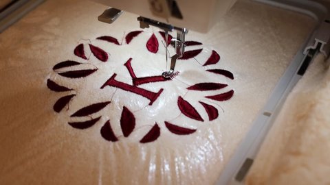 Embroidery design, alphabet monogram K. Machine Embroidery on a cotton towel with burgundy color. Full HD 1920x1080. Close up.