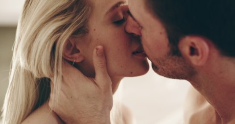 So much chemistry in that kiss. 4K video footage of a young couple sharing an intimate kiss at home.