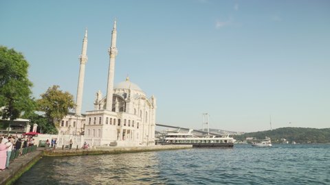 Istanbul, Turkey - September 18, 2021: Awesome view of Ortakoy Mosque and the Bosporus in Istanbul, Turkey. The Bosphorus Bridge (the 15 July Martyrs Bridge) is visible in background.