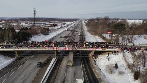 Wide aerial shot of the crowd on the Victoria Bridge located in Vineland, Ontario. People gather to support the Canadian Truckers. Freedom Convoy- 4K, 29.97