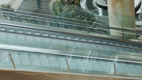 Top View and slow motion of two metal escalator is moving up and down to in department store or train station with beautiful sun light, it shows concept of transportation for urban life in the city.