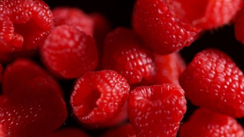 Super Slow Motion Detail Shot of Flying and Rotating Fresh Raspberries at 1000fps.