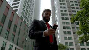 A serious middle-aged businessman in luxurious clothes in the financial district of a metropolis uses reads the news press from the newspaper near the business building. - Powered by Shutterstock - Get 15% off with code: PIKWIZARD15