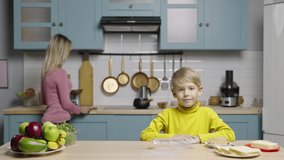 Young woman and boy prepare healthy snack and put it in lunchbox. Mom and son filming stories for social media cooking blog. Family bloggers, culinary account. Slow motion ready, 4K at 59.97fps.