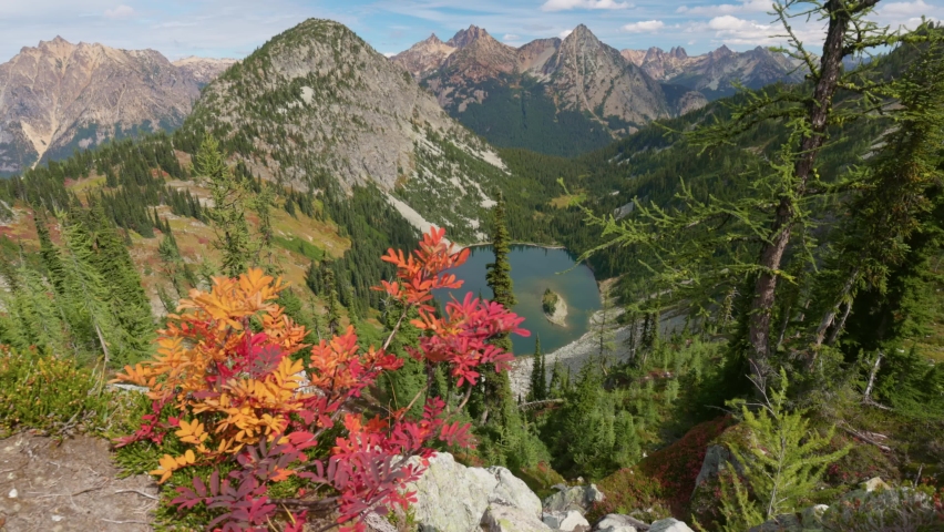 Mountains and lake in North Cascades national park, USA. Autumn in the mountains. Nature of the United States of America, gimbal shot. Red-yellow leaves on the background of the mighty mountain peaks