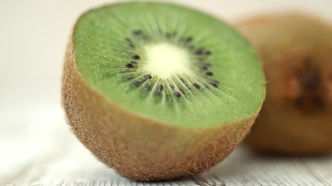 Sliced in half Kiwi fruit against a white rustic background HD stock footage