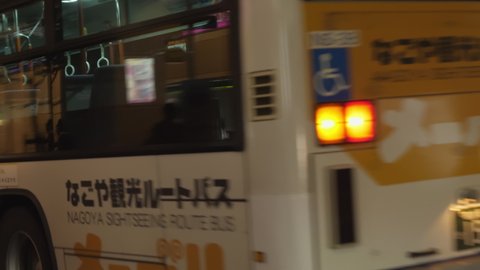 Nagoya.Japan-October 31.2019: Bus pulling up at a stop in Nagoya Japan. Public transport. Metropolitan traffic. Japanese text. Camera slowly zooming out and turning left.