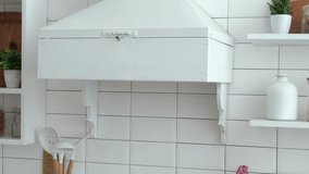 Hands of a young man hanging a hand-crafted wreath of green eucalyptus leaves on a white kitchen - Powered by Shutterstock - Get 15% off with code: PIKWIZARD15