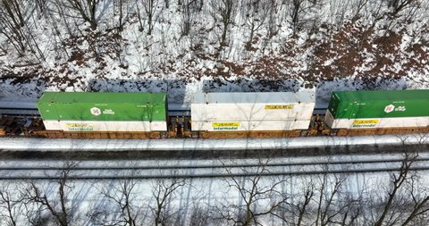 Altoona , PA , United States - 01 22 2022: JB Hunt Intermodal container shipping via freight cargo railroad train. Aerial view.