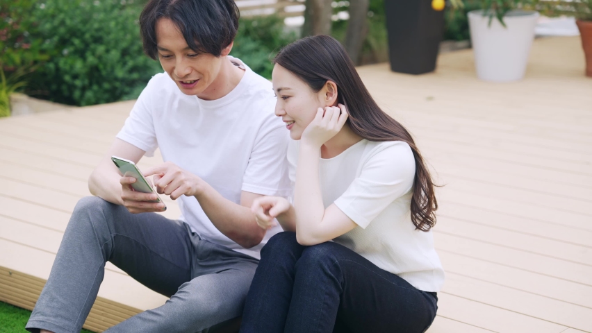 Young asian couple watching a smart phone. Video distribution service. Royalty-Free Stock Footage #1086478076