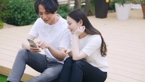Young asian couple watching a smart phone. Video distribution service.