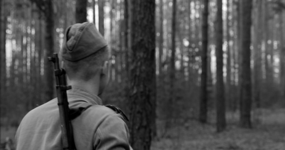 Man Dressed As Russian Soviet Infantry Red Army Soldier Of World War II Marching Walking Along Forest Lane Road In Spring Autumn Day. Black And White Colors.