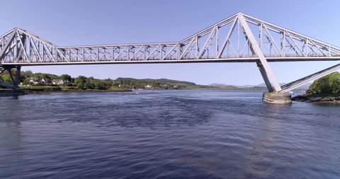 Right to left aerial shot tracking the Connel Bridge on a clear day looking towards Mull