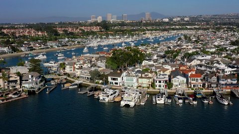 Ultra wealthy oceanfront homes, mansions and luxurious lifestyles of the rich and famous in Balboa Island and Newport Beach, California. Yachts, paddle boarders, leisure, holiday, vacation, activity. 