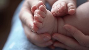 Baby Feet On Mother Hands. Cute Tiny Newborn Kid's Legs On Female Embrace Closeup. Mom And Her Child. Happy Family Concept. Beautiful Conceptual Video Of Maternity. Adorable Tiny Toes Selective Focus