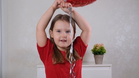 funny little girl with three heart shaped balloons for valentines day. family love. gifts for the holiday. happiness and kisses