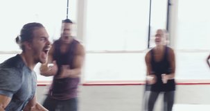 Getting the group all pumped up. 4k video of a group of people celebrating after a workout at the gym.