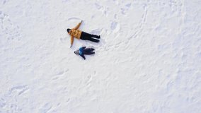 mom and baby make a snow angel. aerial photography - Powered by Shutterstock - Get 15% off with code: PIKWIZARD15