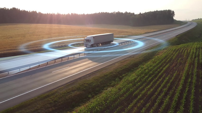 Aerial view of autonomous truck driving on autopilot on a highway with traffic sensors scanning surroundings. Cargo delivery, transportation of the future. Artificial intelligence. Self driving. High