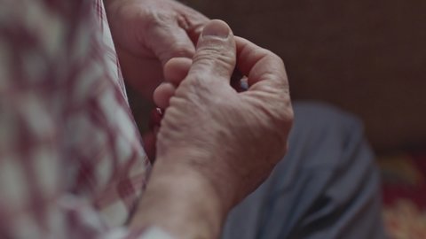 Close-up view of the hands of a Muslim old man holding a rosary. Muslim old man praying with a rosary in his hand.