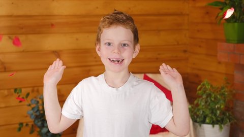 Valentine's Day kids. Cute little blond boy rejoices with flying red heart shaped confetti on Valentine's Day. Congratulation. 4k video