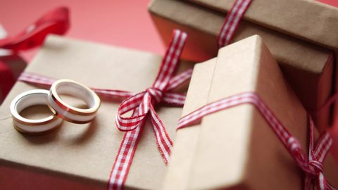 wedding ring and gift box and rose flower on red 