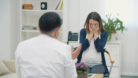 4k video of sad pregnant woman talking with a doctor.