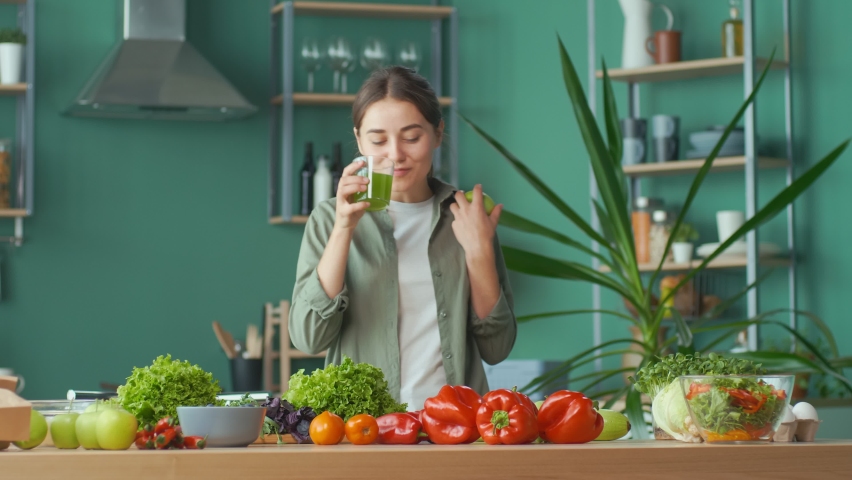 Happy Young Woman Enjoying The Process of Cooking, Having Fun Playing With an Apple at the Kitchen Table with Organic Products. Diet, Proper Nutrition, Raw Food Diet. Nutrition and Dietetics. | Shutterstock HD Video #1086519206