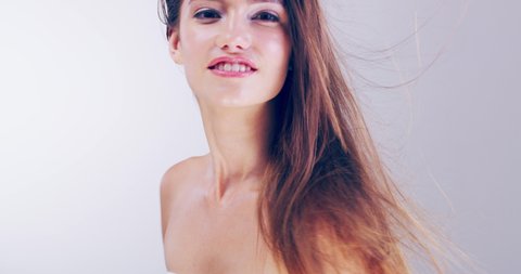 Let your gorgeous hair loose and enjoy it. 4k video footage of a beautiful young woman playing with her hair in the studio.