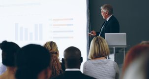 Presentation skills that make an impact. 4k video footage of a mature businessman delivering a presentation at a conference.