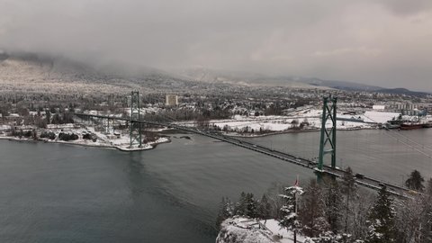Vancouver, British Columbia, Canada - Aerial view of Stanley Park, Lions Gate Bridge and North Vancouver on a snowy winter day in 4K