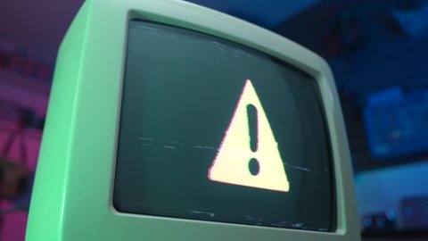 Warning symbol sign is shown on an old CRT TV screen from the 1990 1980.