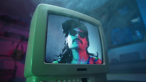 Cool man from the 1990 1980 wearing sunglasses displayed on.a CRT old vintage TV.