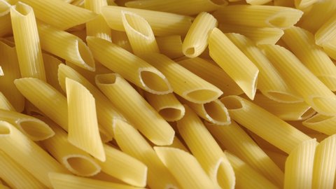 Top view of raw fresh pasta penne rigate rotate on tray. Penne Rigate macaroni. Traditional Italian Cuisine. Durum wheat pasta. Food background.