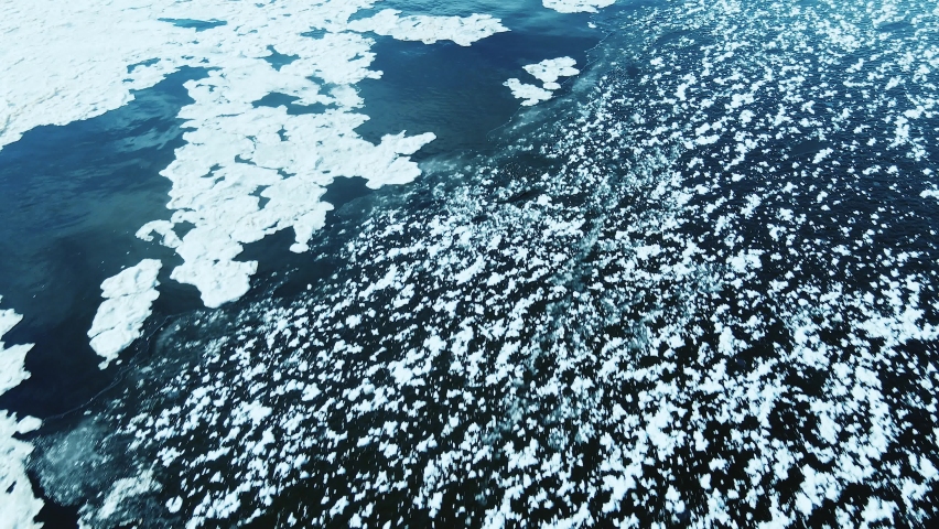 Flying over the open ice with textures and ice patterns.