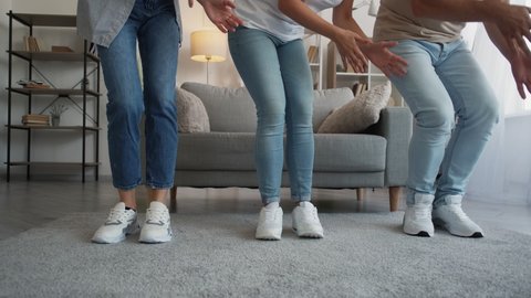Family joy. Funny entertainment. Video challenge. Unrecognizable mother father and daughter dancing moving hands all together in light home interior motion view.