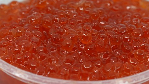 Grains of Red Caviar Rotated Background, Macro. Texture of Expensive High Quality Luxury Caviar. Seafood