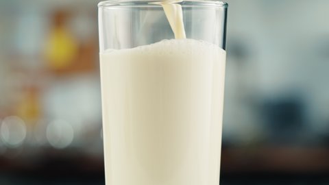 Milk in glass cup close-up. Glass with yogurt, dairy products concept. Drinking fresh lactose-free milk in morning.