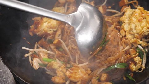 close up of moving wok with a pad thai