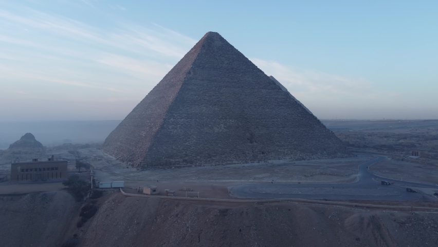 Drone video of the Giza pyramids at sunrise, construction cranes and building sites. Cairo - Egypt Royalty-Free Stock Footage #1086538487