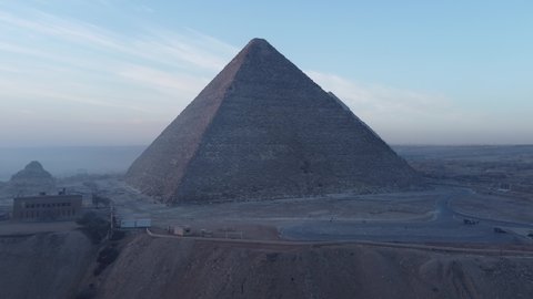 Drone video of the Giza pyramids at sunrise, construction cranes and building sites. Cairo - Egypt