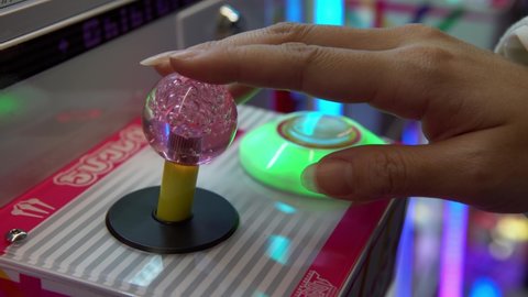 Tokyo, Japan-02 February, 2020: Woman used joystic and button on arcade type robotic claw machine grabber game. Mechanical arm that selecting dolls. Vending machines games to buy collections toys