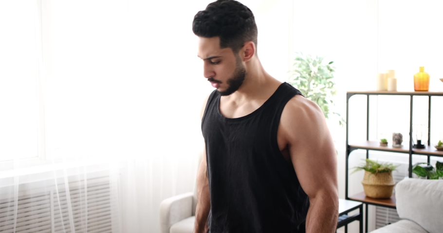 Young man doing biceps exercise with dumbbells