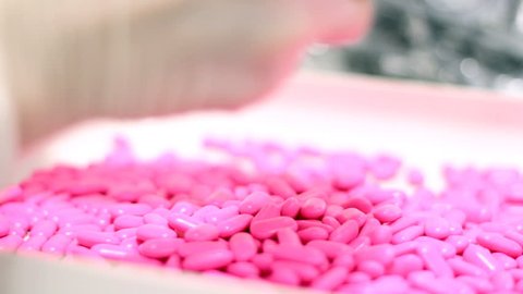 Technicians inspecting the quality of pills at a pharmaceutical plant. Stock-video