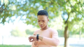 Sport african american woman looking smart watch at modern track. runner using smartwatch fitness bracelet Portrait black female athlete checking result jogging in sportswear in street urban city park - Powered by Shutterstock - Get 15% off with code: PIKWIZARD15